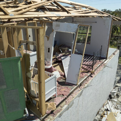 Damaged house roof and walls after hurricane Ian in Florida. Consequences of natural disaster.