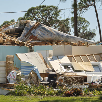 Severely damaged by hurricane Ian house in Florida mobile home residential area. Consequences of natural disaster.